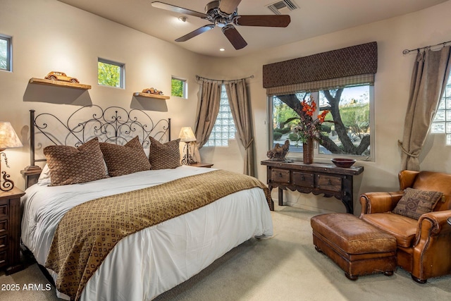 carpeted bedroom featuring multiple windows and a ceiling fan