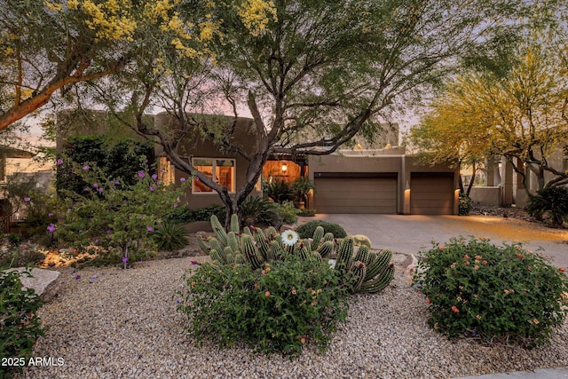 view of front of house featuring stucco siding, driveway, and an attached garage