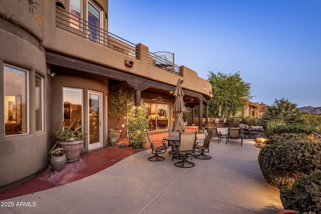 view of patio with a balcony and outdoor dining space