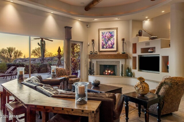 living room featuring recessed lighting, a lit fireplace, beam ceiling, and tile patterned floors