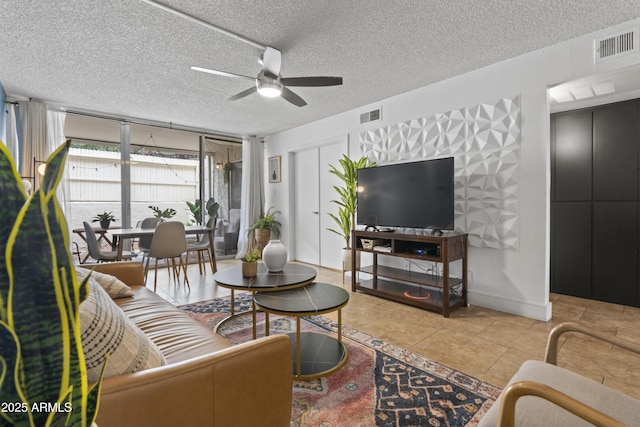 tiled living room with ceiling fan and a textured ceiling