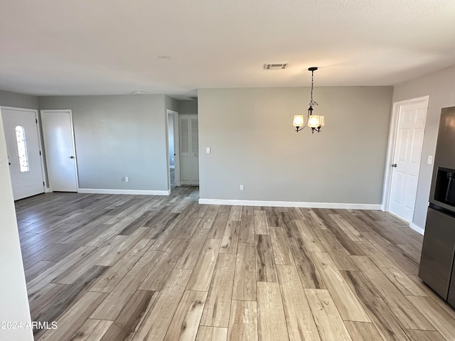 interior space featuring an inviting chandelier and light wood-type flooring