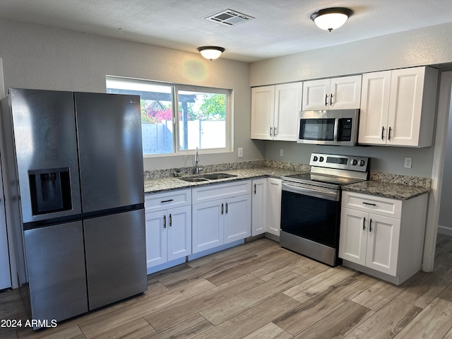 kitchen featuring white cabinets, light hardwood / wood-style floors, stainless steel appliances, and sink