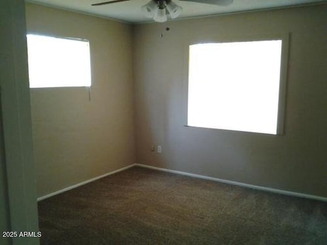 carpeted spare room featuring ceiling fan