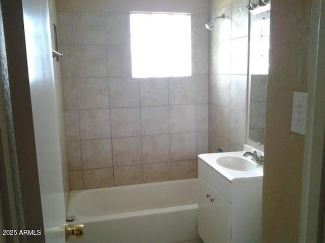 bathroom featuring tiled shower / bath combo and vanity