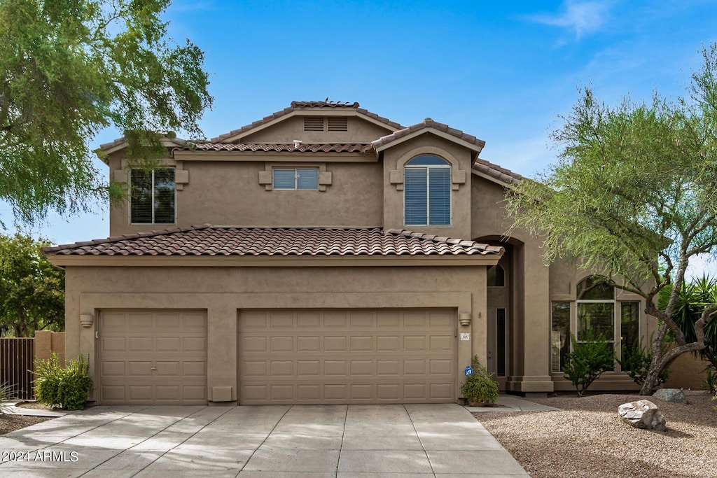 mediterranean / spanish-style home with a garage