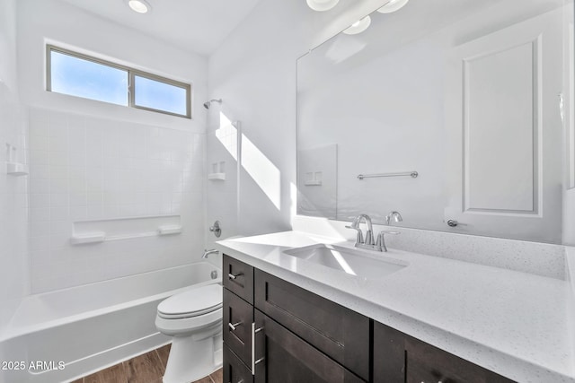 full bathroom with washtub / shower combination, vanity, hardwood / wood-style flooring, and toilet