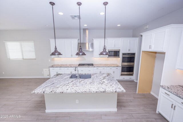 kitchen featuring pendant lighting, sink, and an island with sink