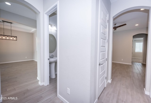 hallway with sink and light wood-type flooring