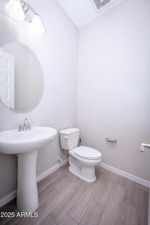 bathroom with wood-type flooring and toilet