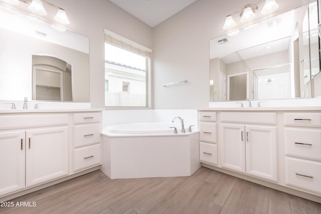 bathroom with shower with separate bathtub, vanity, and wood-type flooring