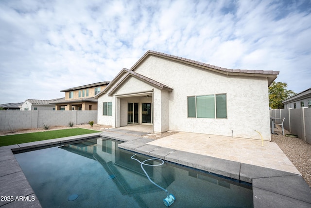 back of property with a patio and a fenced in pool