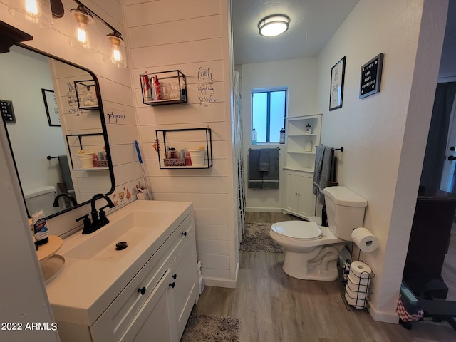 bathroom featuring vanity, wood-type flooring, and toilet