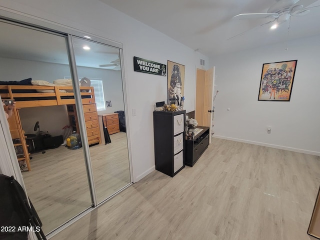 interior space with a closet, ceiling fan, and light wood-type flooring