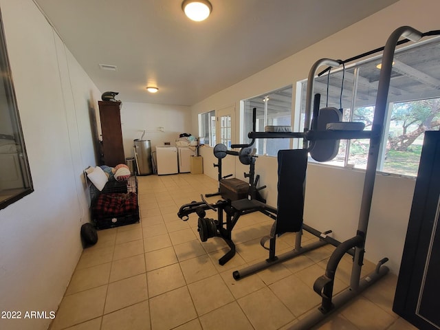 workout room featuring separate washer and dryer, light tile patterned floors, and a wealth of natural light