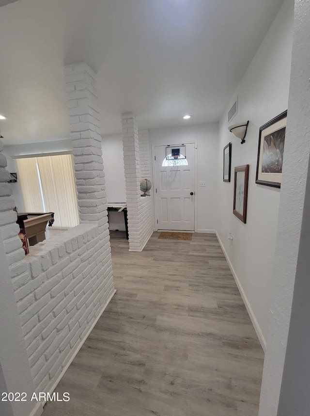 hall featuring ornate columns and light hardwood / wood-style floors