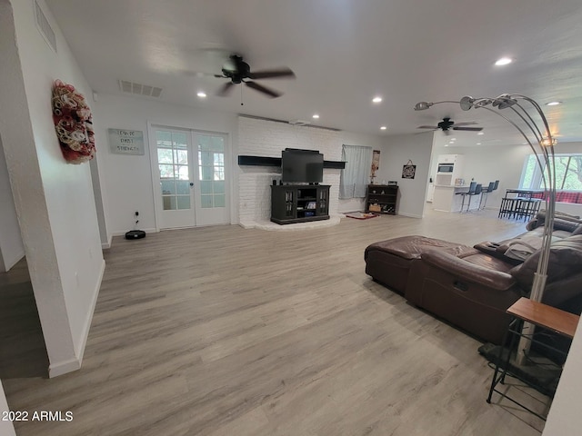 living room with hardwood / wood-style flooring, ceiling fan, and french doors