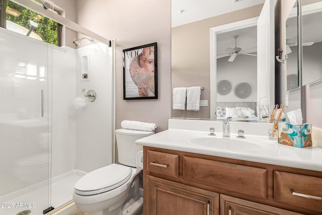 full bath featuring vanity, a ceiling fan, toilet, and a shower stall