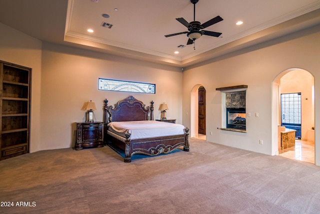 bedroom with crown molding, a tray ceiling, and carpet flooring