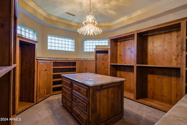 spacious closet with a raised ceiling, carpet, and an inviting chandelier