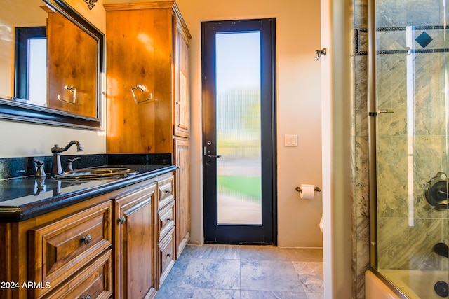 bathroom with vanity and shower / bath combination with glass door