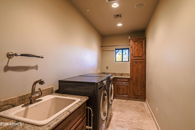 laundry room with cabinets, separate washer and dryer, and sink