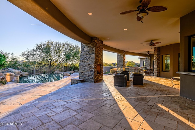 patio terrace at dusk featuring ceiling fan