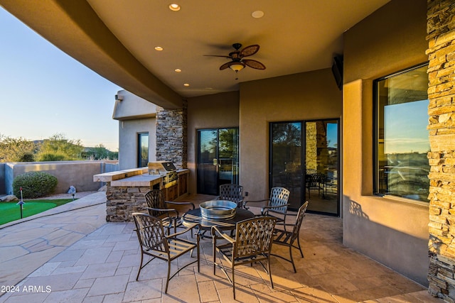 view of patio / terrace with exterior kitchen, ceiling fan, and a bar