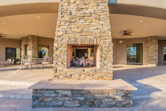 unfurnished living room featuring exterior fireplace and ceiling fan