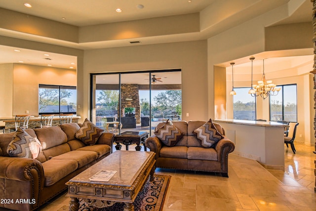 living room with a high ceiling, a wealth of natural light, and an inviting chandelier