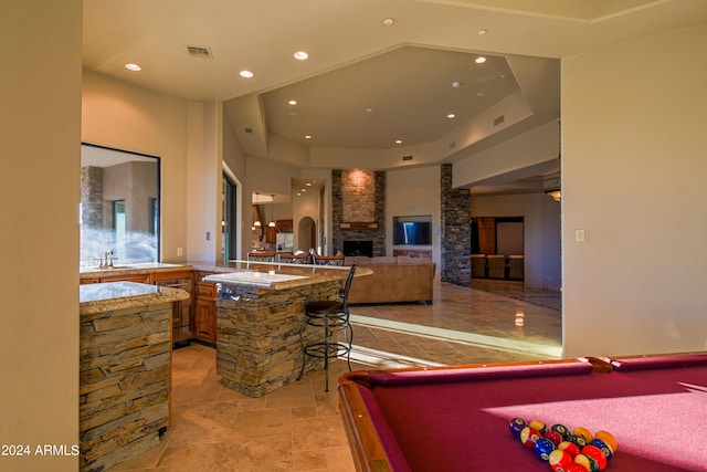 playroom featuring billiards, a fireplace, and a raised ceiling