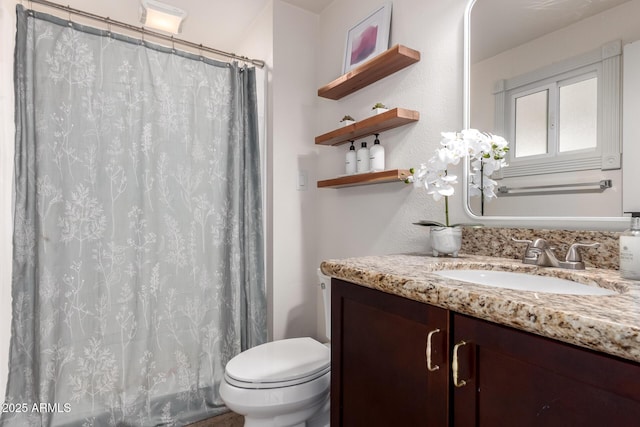 bathroom with toilet, a shower with shower curtain, and vanity