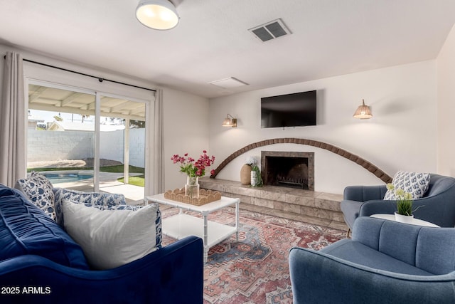 living area with a brick fireplace and visible vents