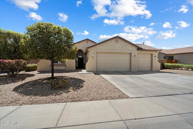 view of front of property featuring concrete driveway, stucco siding, fence, a tiled roof, and a garage