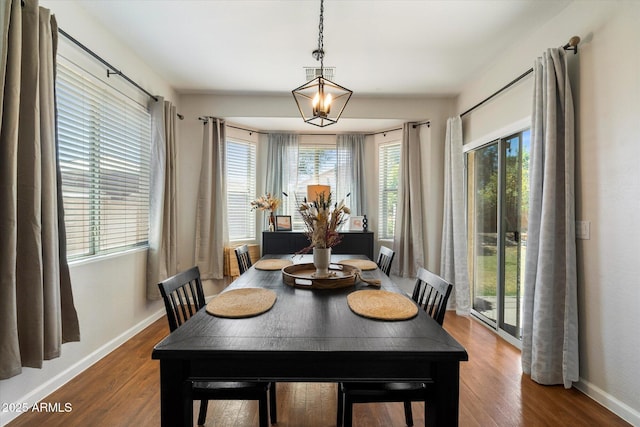 dining room with baseboards, visible vents, and wood finished floors