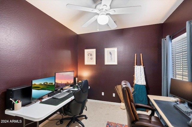 office area with baseboards, ceiling fan, a textured wall, and light carpet