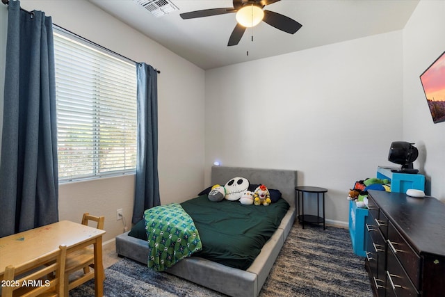 bedroom featuring baseboards, visible vents, dark colored carpet, and a ceiling fan
