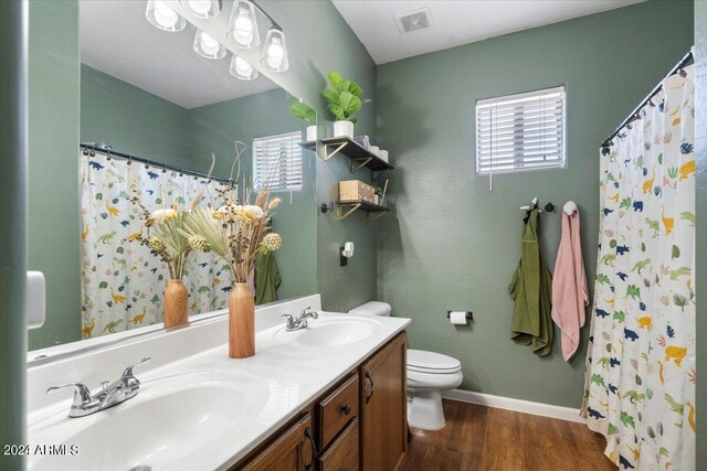 bathroom with visible vents, a sink, toilet, and wood finished floors