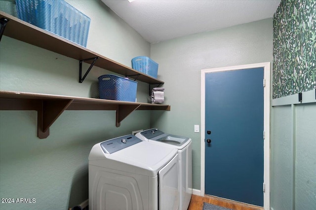laundry area featuring washer and clothes dryer, baseboards, laundry area, and wood finished floors