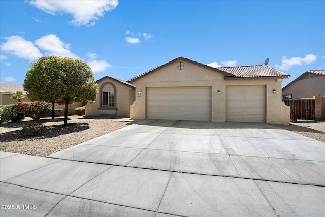 view of front facade with driveway, fence, an attached garage, a tile roof, and stucco siding