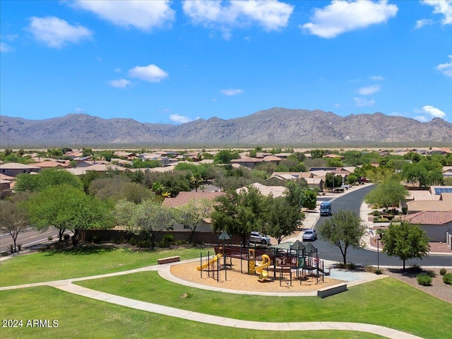 surrounding community featuring playground community, a mountain view, and a yard