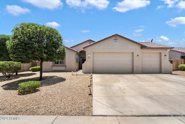 view of front of home with driveway, fence, a tiled roof, a garage, and stucco siding