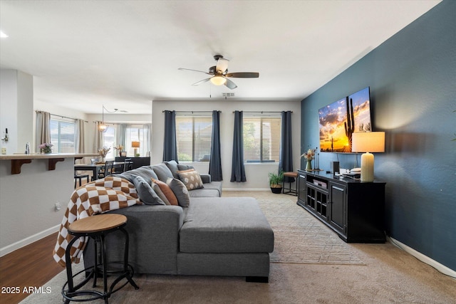 living room with baseboards and a ceiling fan