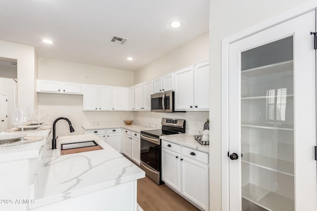 11891 N 147th Dr, Surprise, AZ 85379 - kitchen featuring a sink, visible vents, light wood-style flooring, white cabinets, and appliances with stainless steel finishes