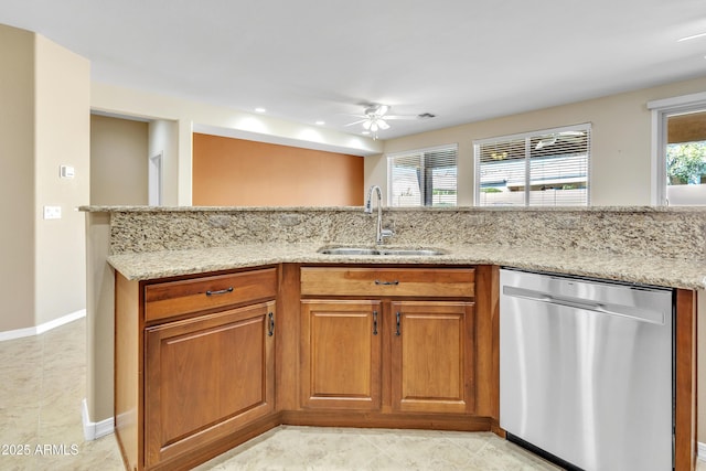 kitchen with dishwasher, a sink, light stone countertops, and brown cabinets