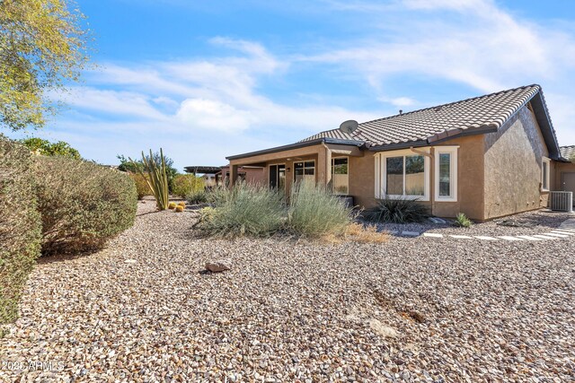 view of front of home with central air condition unit, a tiled roof, and stucco siding