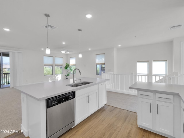 kitchen with dishwasher, sink, white cabinets, and an island with sink