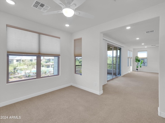 unfurnished room featuring light carpet and ceiling fan