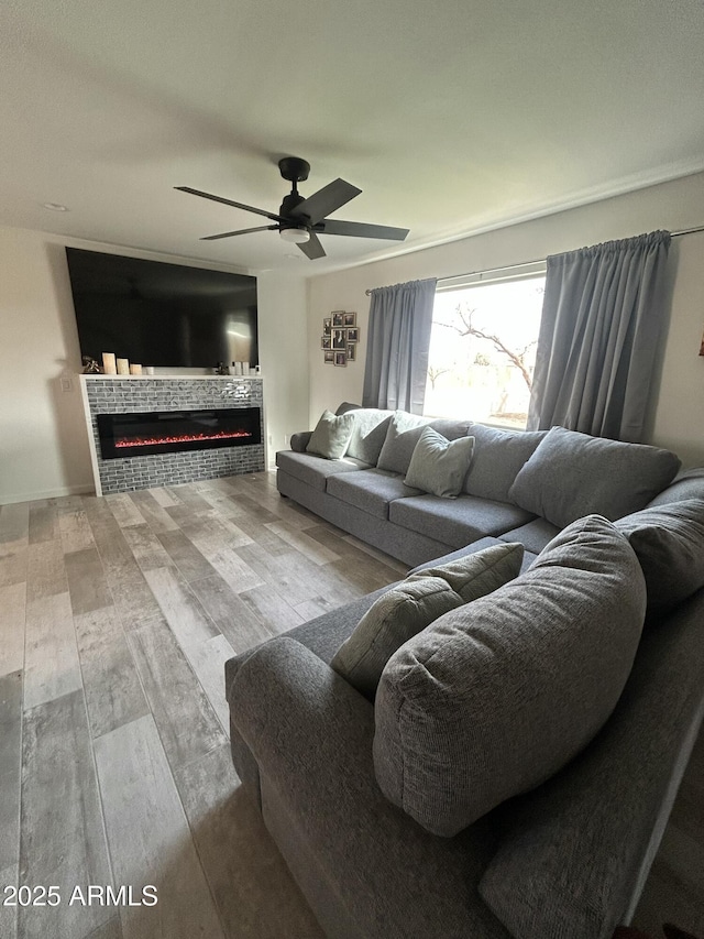 living room with a tiled fireplace, hardwood / wood-style flooring, and ceiling fan