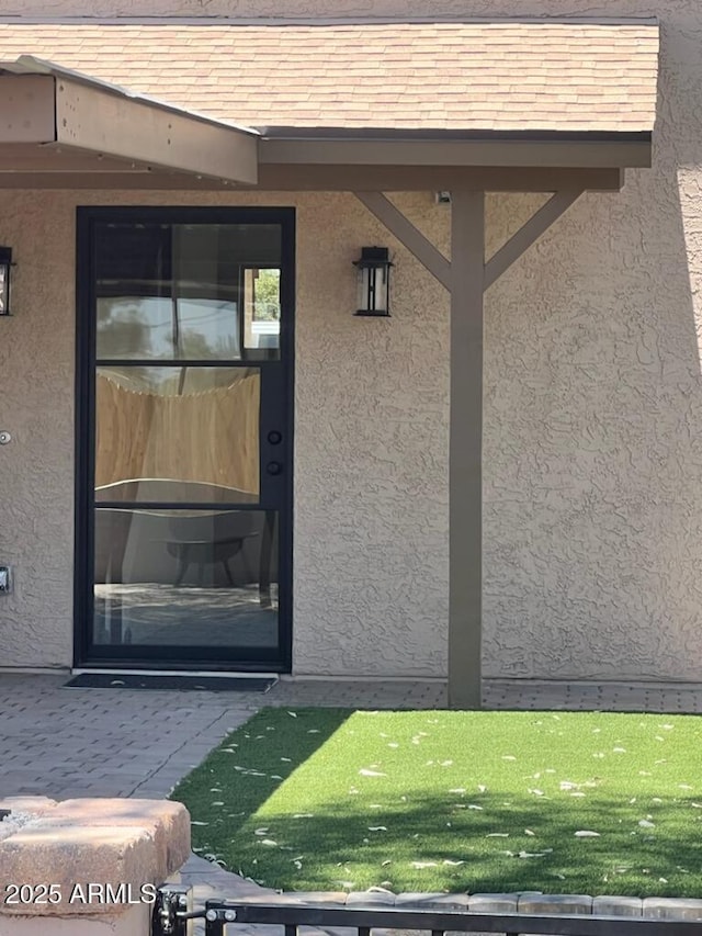 view of exterior entry with a patio area